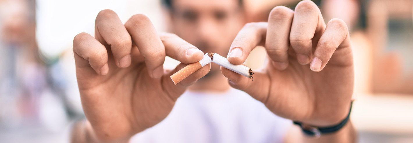 Hands snapping a cigarette in half